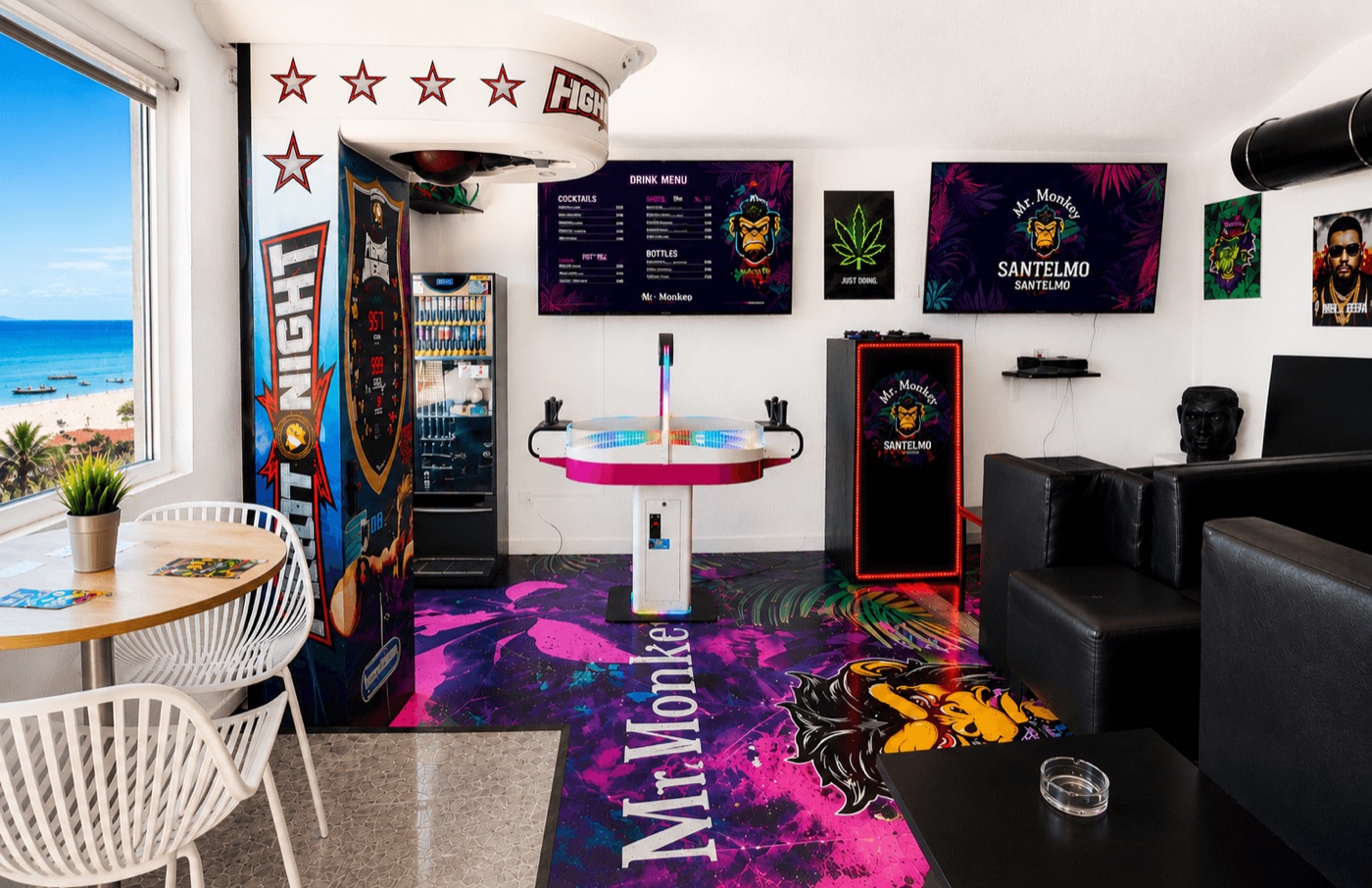 Inside Mr. Monkey Club 1: seafront lounge with arcade, sofas and terrace view